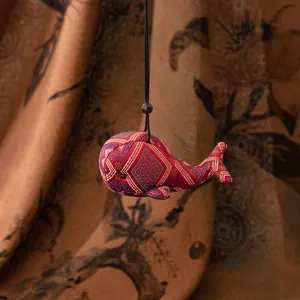 Détail d'un pendentif baleine en soie fait main avec motifs de broderie ethniques