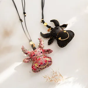 Collier fait main avec pendentif vache en soie, cordon noir ajustable et accents dorés