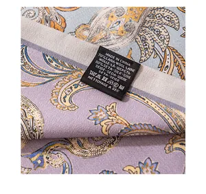 Gros plan de l'étiquette d'un foulard en soie et laine montrant la composition