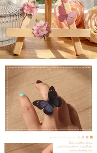 Macro view of butterfly and flower PET stickers on a finger and wooden easel