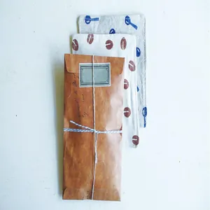Détail d'une enveloppe en papier kraft vintage vieilli avec ficelle et fond en tissu