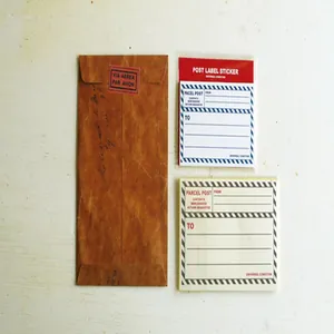 Détail d'une enveloppe kraft vintage et d'autocollants postaux sur fond de bois