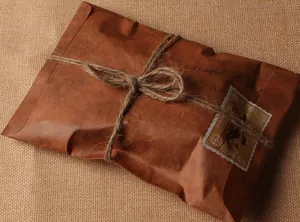 Gros plan d'une enveloppe en papier kraft vintage avec ficelle de jute et timbre