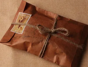 Vue macro détaillée d'une enveloppe vintage en papier kraft avec des timbres rétro et du jute