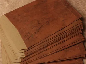 Vue détaillée d'enveloppes en papier kraft vintage empilées avec écriture décorative.