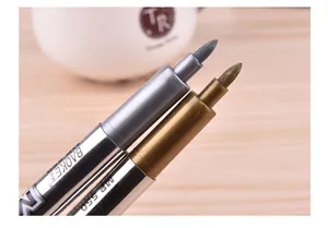 Close-up of gold and silver metallic paint marker nibs showing ink texture
