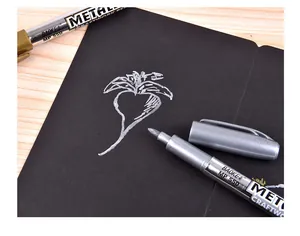 Detailed macro shot of a silver metallic paint pen writing on black cardstock