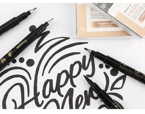 Makro-Detail der flexiblen Pinselspitze des schwarzen Kalligraphiestifts auf weißem Papier.