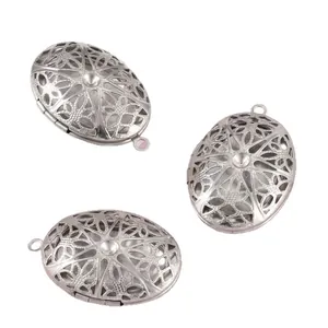 Vue détaillée de trois pendentifs médaillons ovales vintage en argent ajouré fleuri