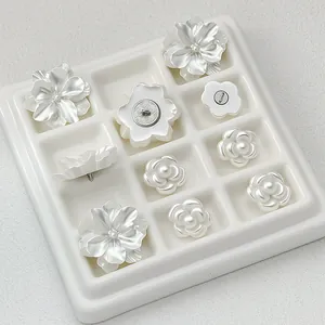 Detailed close-up of decorative white flower-shaped alloy buttons in various styles.