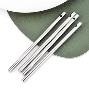 Vue détaillée de tiges cylindriques en acier inoxydable argenté de 10 cm avec trous.