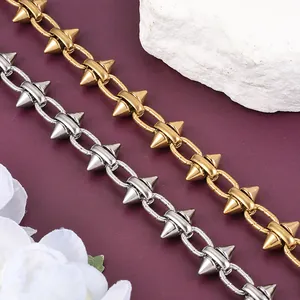 Detailed close-up view of punk style spike stainless steel chains in gold and silver finish