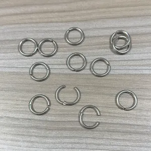 Close-up of stainless steel non-pierced hoop earrings on a wood background.