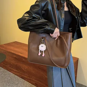 Large vintage brown tote bag with pink fuzzy charm detail macro view