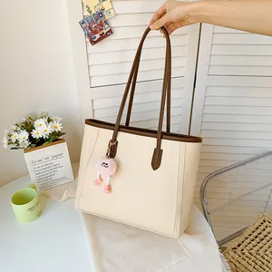 Minimalist cream and brown large capacity tote bag with cute pink plush pendant.