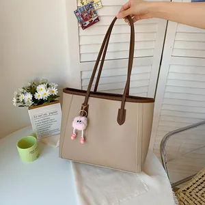 Fashionable khaki large capacity tote bag with brown handles and pink monster charm