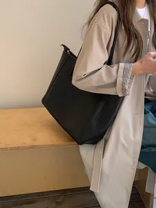 Side view of a stylish large capacity black leather tote bag for the daily commute