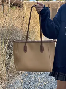 Lifestyle shot of a vintage large capacity khaki tote bag held by a model outdoors