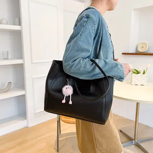 Side view of vintage large black tote bag worn by a model in a bright casual setting