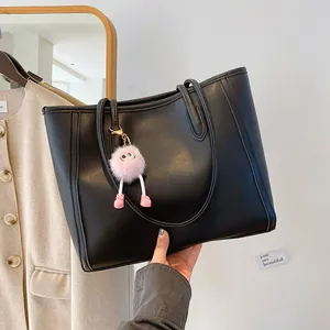 Retro large black faux leather tote bag with cute pink furry keychain for women commute.