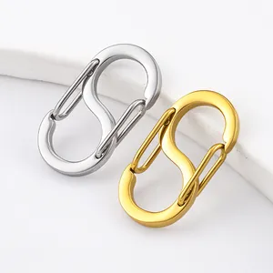 Close-up of polished S-shaped spring carabiners in silver and gold steel finishes.