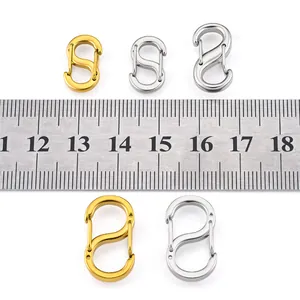 Close-up of polished stainless steel S-shaped carabiner hooks with ruler for size