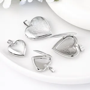 Detail shot of open and closed stainless steel heart locket pendants with floral engravings