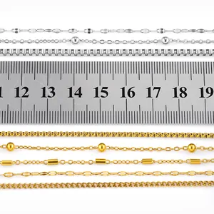 Detail of various titanium steel necklace chains in gold and silver with ruler for scale.
