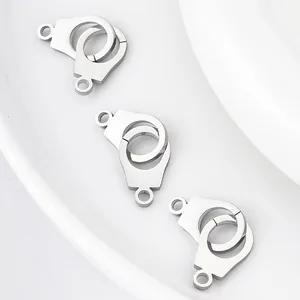 Macro detail of three polished stainless steel handcuff charms on a white surface.