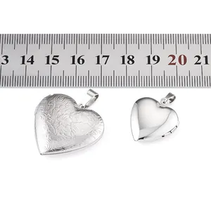 Detailed view of engraved and polished heart lockets with ruler for size reference.