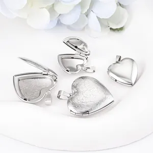 Detail view of polished and engraved stainless steel heart-shaped openable lockets