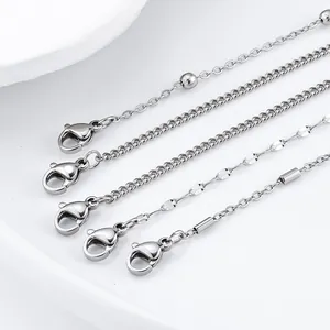 Detailed view of five varied stainless steel chain link bracelets with lobster clasps