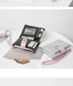 Detailed view of short pearl wallets with cracked texture and pink wrist strap