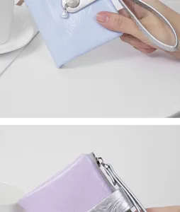 Close-up of lavender crackle texture wallet with pearl charm and silver wrist strap.
