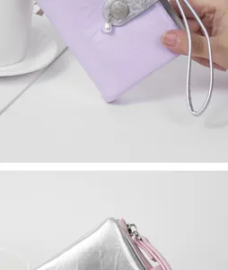 Close-up of stylish cracked leather coin purse with elegant pearl charm and wristlet