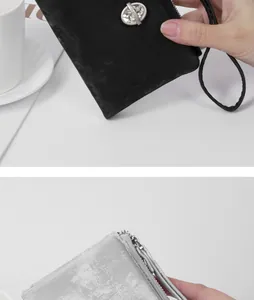 Close-up of glittery small wallet featuring rhinestone hardware and a wrist strap