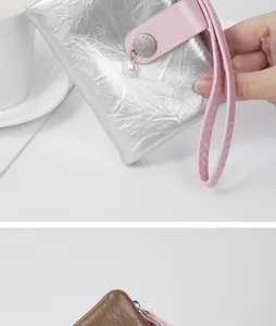 Close-up of silver burst texture wallet with elegant pearl charm and pink wrist strap