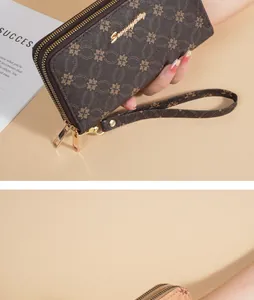 Close-up of a luxury brown floral pattern long wallet with double zippers and strap.