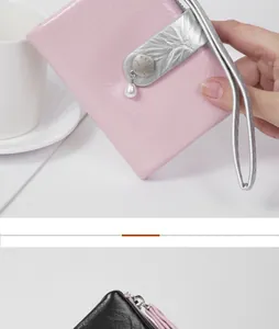 Close-up of pink crackled leather wallet with pearl charm and silver wristlet strap