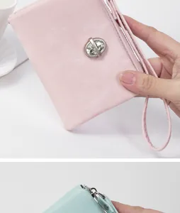 Close-up view of a pink women's wristlet wallet featuring a stylish crystal stud