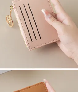 Detailed view of a slim pink card holder for women with zipper pocket and gold keychain