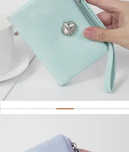 Close-up of a mint green women's pouch with a wrist strap and rhinestone detail