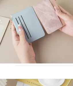 Close-up of slim pastel card holder with multiple slots and zipper pocket