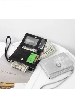 Detail view of women's short wristlet wallet with rhinestone clasp and compartments