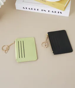 Close-up of slim lime green and black card holders with gold-tone keychains and zippers