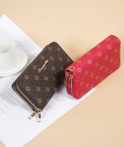 Detailed view of two long double-zippered women's wallets with floral monogram patterns.