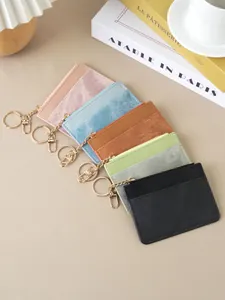Slim multi-color women's card holders with gold keychains and zippers on beige background.