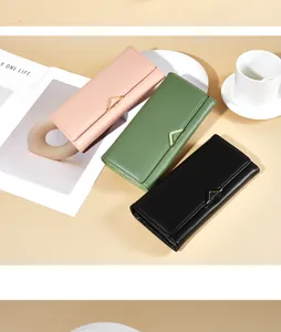 Elegant long PU leather wallets for women shown in pink green and black colors on tabletop