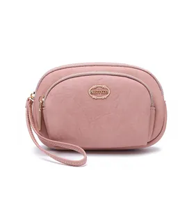 Close-up of pink double-zippered women's wallet with wrist strap and gold logo