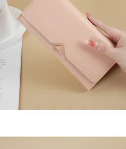 Close-up of elegant pink PU leather long wallet for women with V-shaped metal buckle